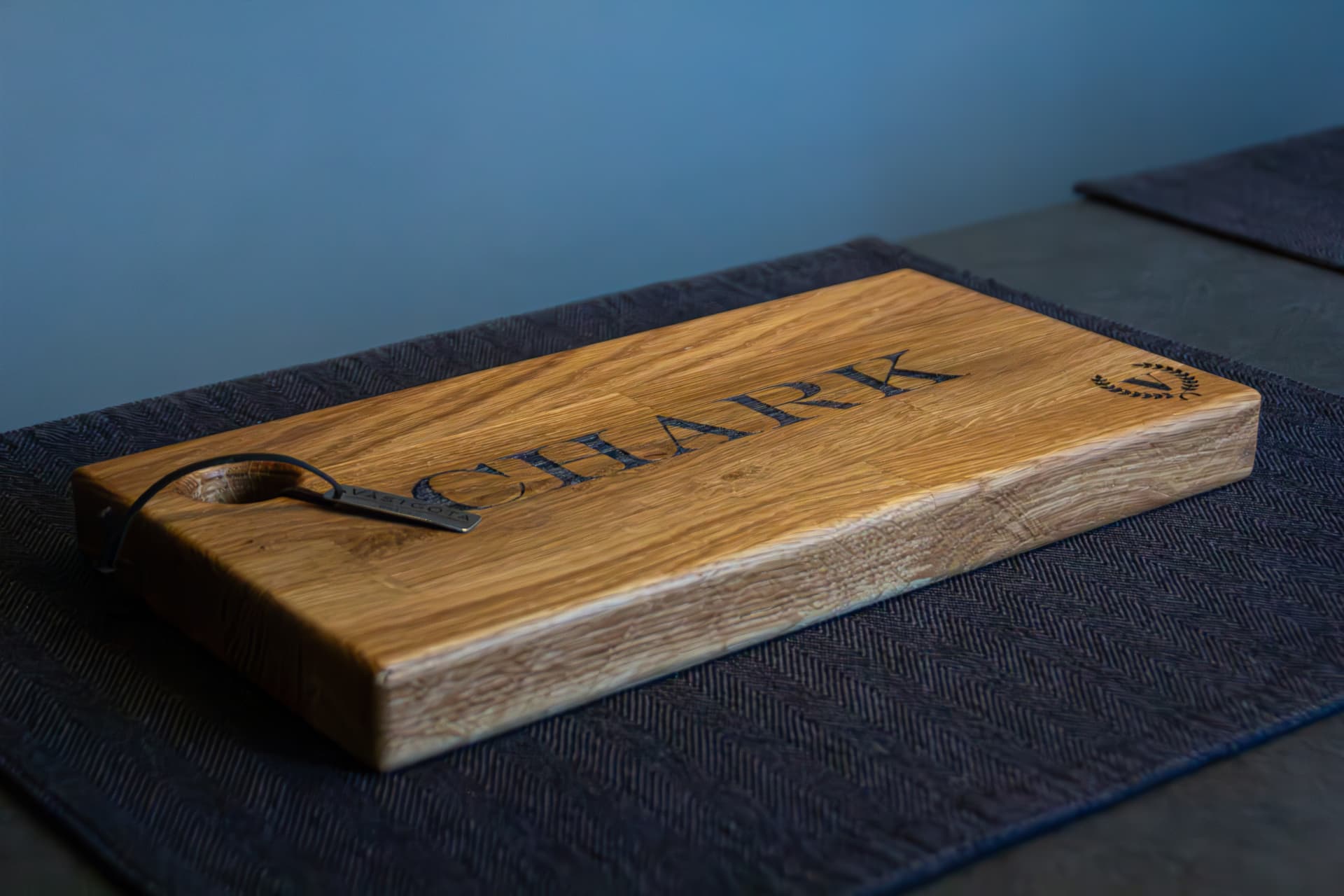 Charkbricka "CHARK" sedd från sidan med läderrem